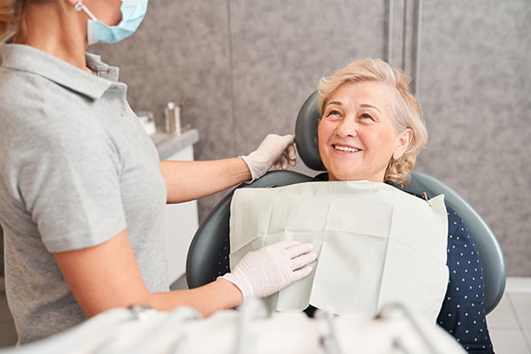 Dentist consulting with a patient about customized full-arch implant treatment, including All-on-4 and All-on-X options