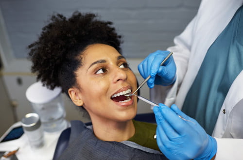 Patient smiling during dental examination and professional teeth cleaning at Mississauga dental clinic.