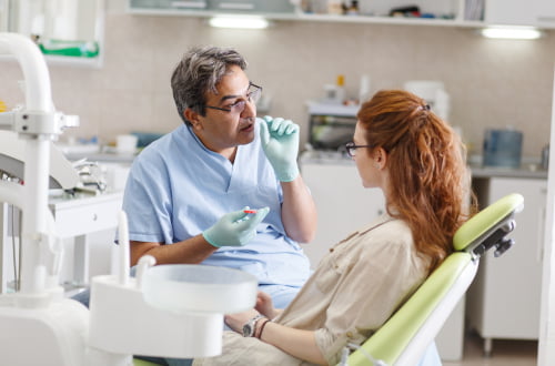 A dentist performing a dental examination for a patient covered by the Canadian Dental Care Plan.