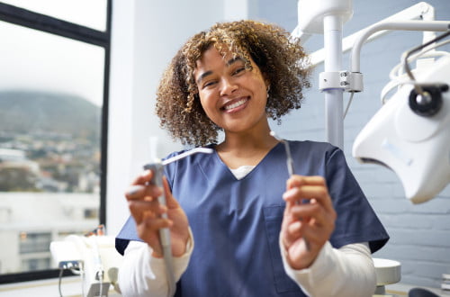 A dental hygienist holding professional dental cleaning instruments in Mississauga