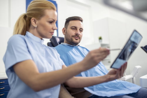 Dentist explaining dental X-ray results to a patient during a consultation at a dental clinic in Mississauga.