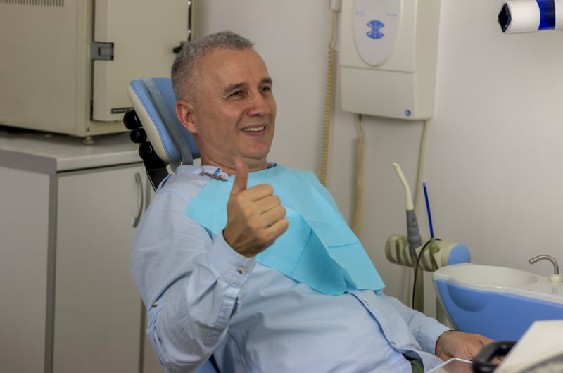 Smiling patient giving a thumbs up after a dental visit in Mississauga