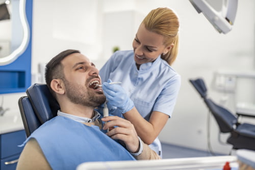 A dentist performing preventive dental care and examination for a patient at a family dental clinic in Mississauga.