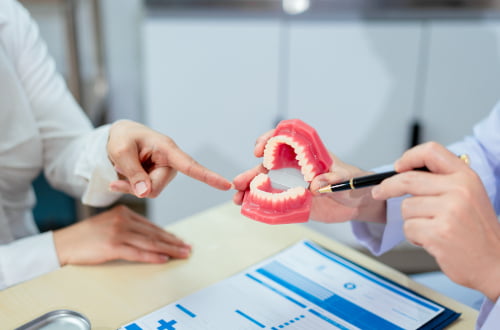 A dentist explaining restorative dental treatments such as fillings and root canal therapy.