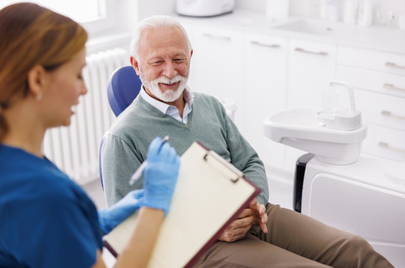 Dentist discussing a patient's dental records during a regular check-up in Mississauga