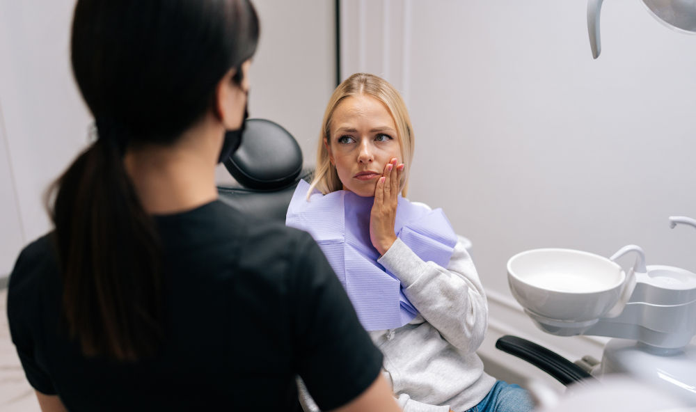 Dentist consulting patient about intermittent tooth pain and dental symptoms