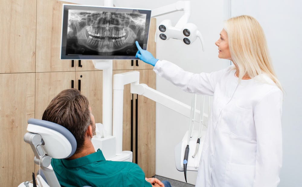Young woman dentist discussing wisdom tooth options with patient in dental clinic