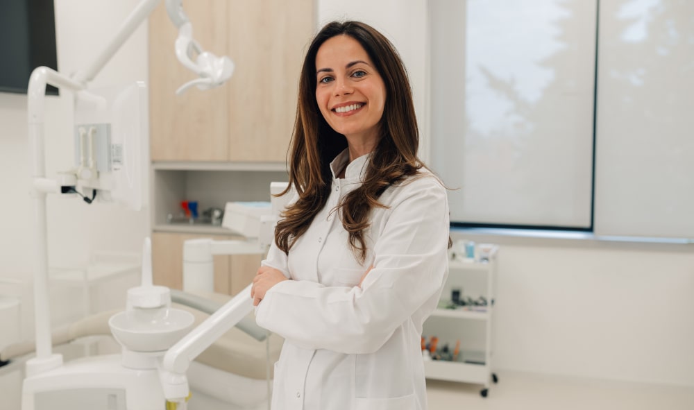 Smiling female dentist standing in modern dental clinic Professional dentist in clinic offering bruxism diagnosis and treatment options