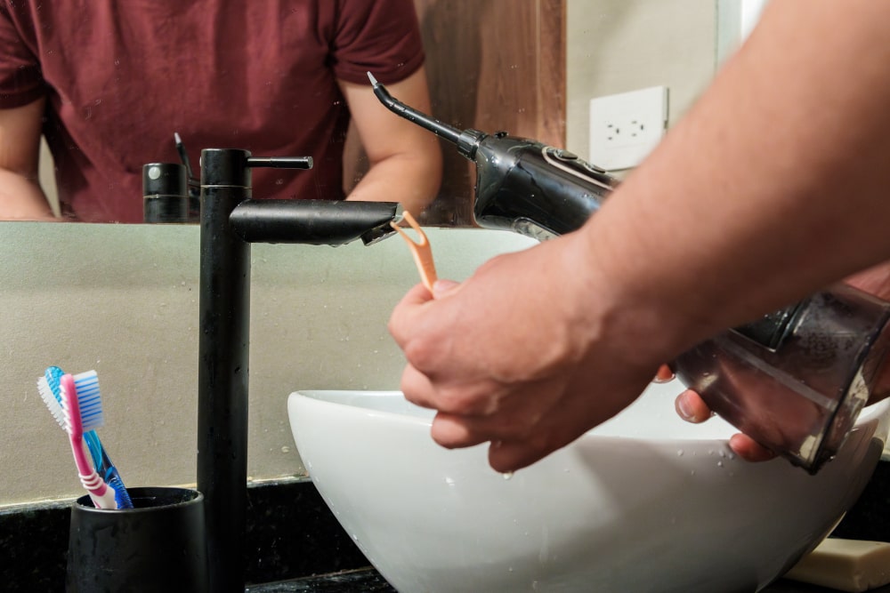 Teenager flossing around braces using a water flosser