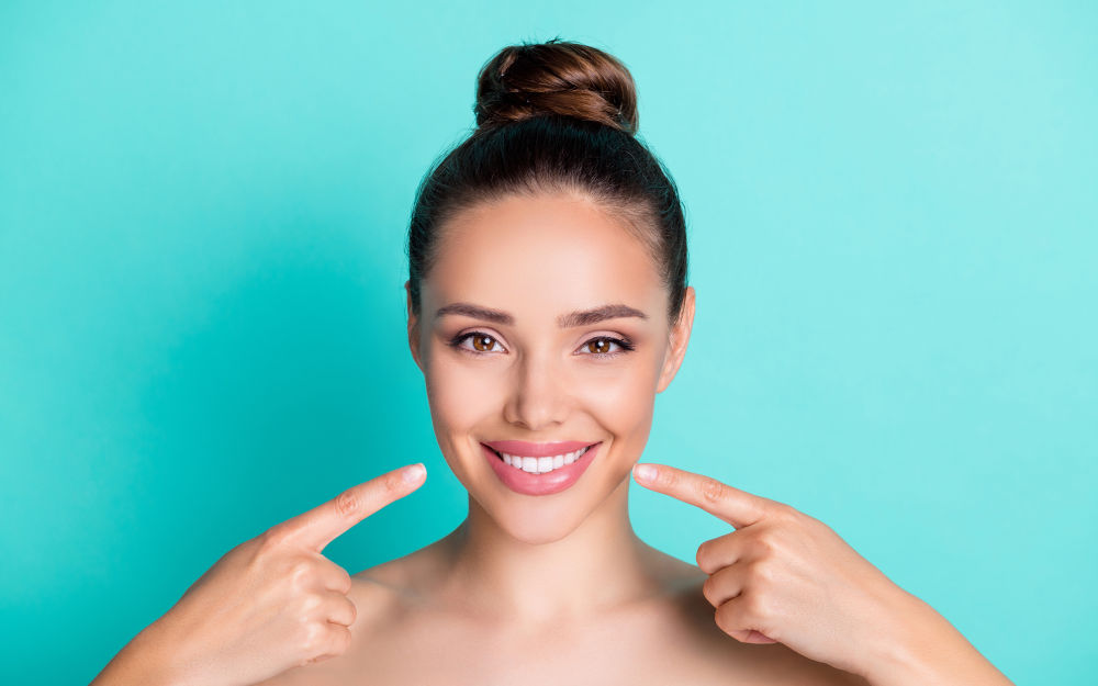 Close-up of a smiling woman, illustrating natural, well-planned porcelain veneers designed for long-term aesthetics and oral health.