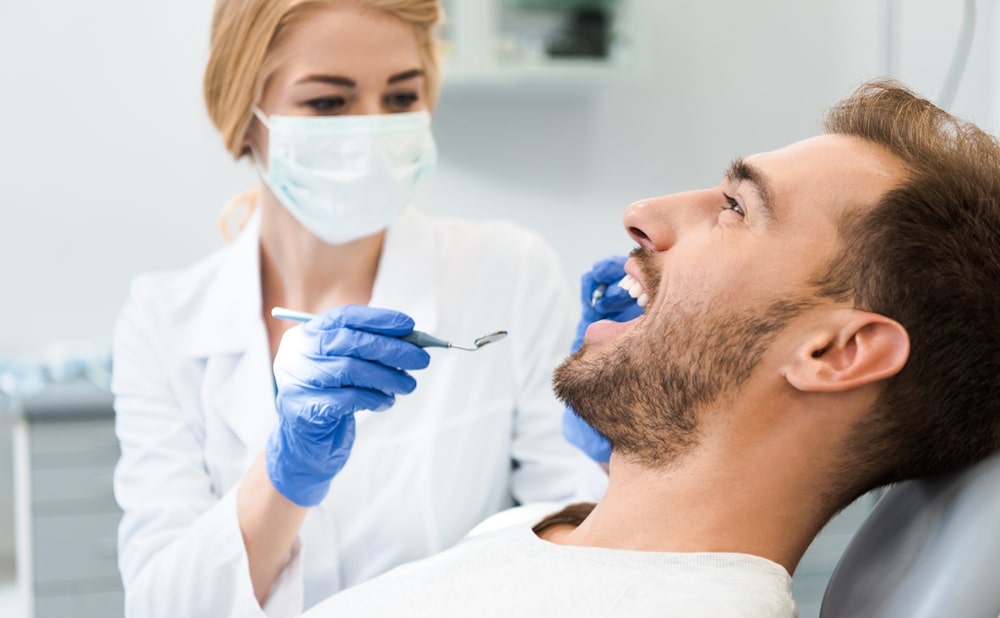 The Importance of Preventive Dental Care for Long-Term Oral Health Dentist explaining preventive care benefits to a smiling patient in a dental clinic